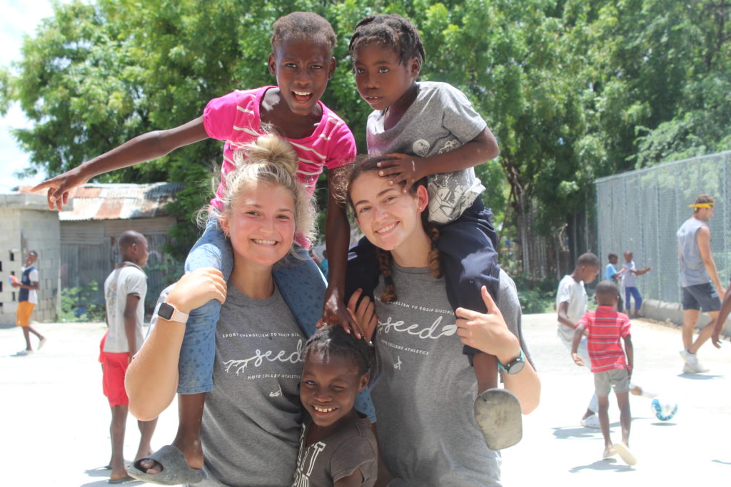 Two Hope student-athletes play with three youth in Africa.