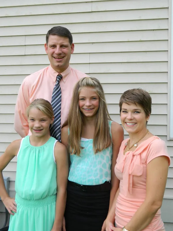 Chris VanderSlice stands with his wife and two daughters.