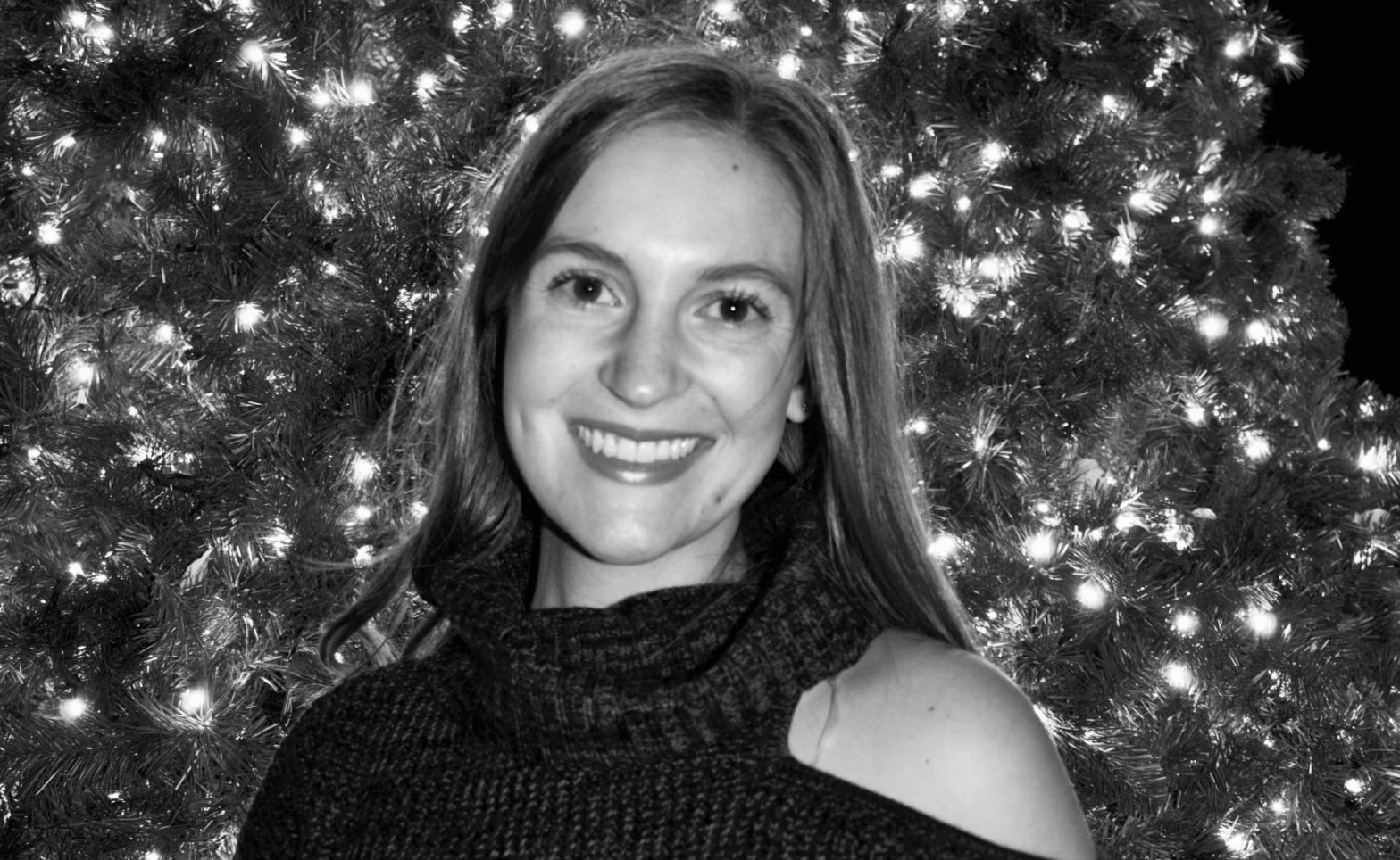 Hannah Tegtmeyer in front of a lighted tree in black and white