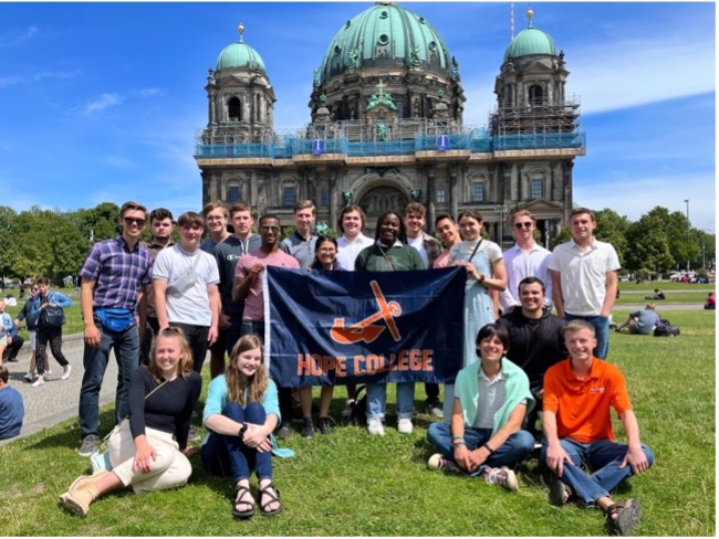 Hope Engineering students display the Hope College anchor flag in front of the Berlin Cathedral
