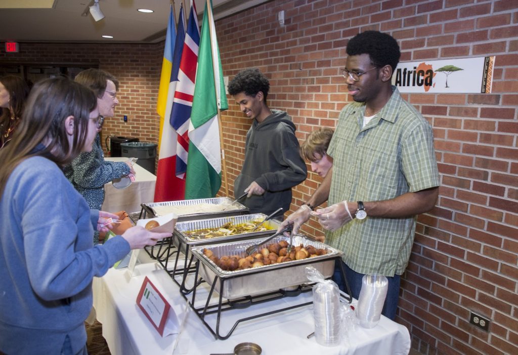 Two students serve Jollof rice & puff puff at the International Food Festival at Hope College