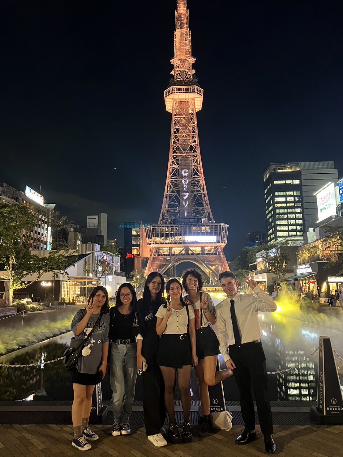 students in front of the Nagoya TV tower, posing.