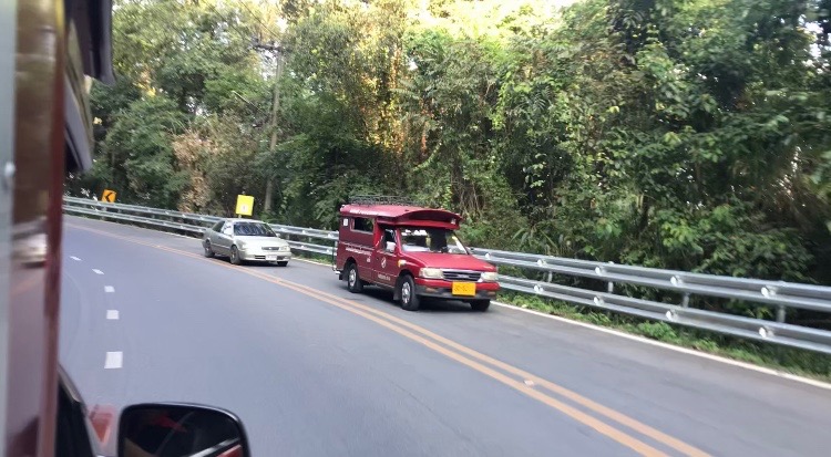 Passing by a red truck on the way up to Doi Suthep