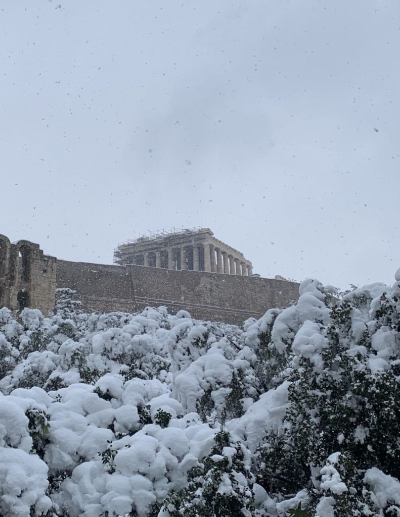 Ancient ruins of the Acropolis covered in snow. 