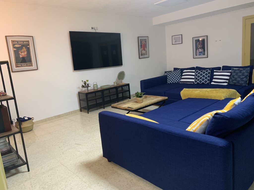 Our TV room with convertible couch beds for movie nights and with a book shelf full of board games, books, and a karaoke speaker with microphones