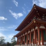 Kofuku-ji Buddhist temple main hall. Side view of a red elevated building with a blue sky background.