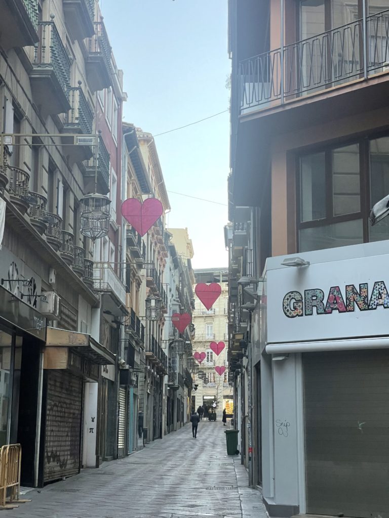 A picture of the street with hearts hanging in the air. 