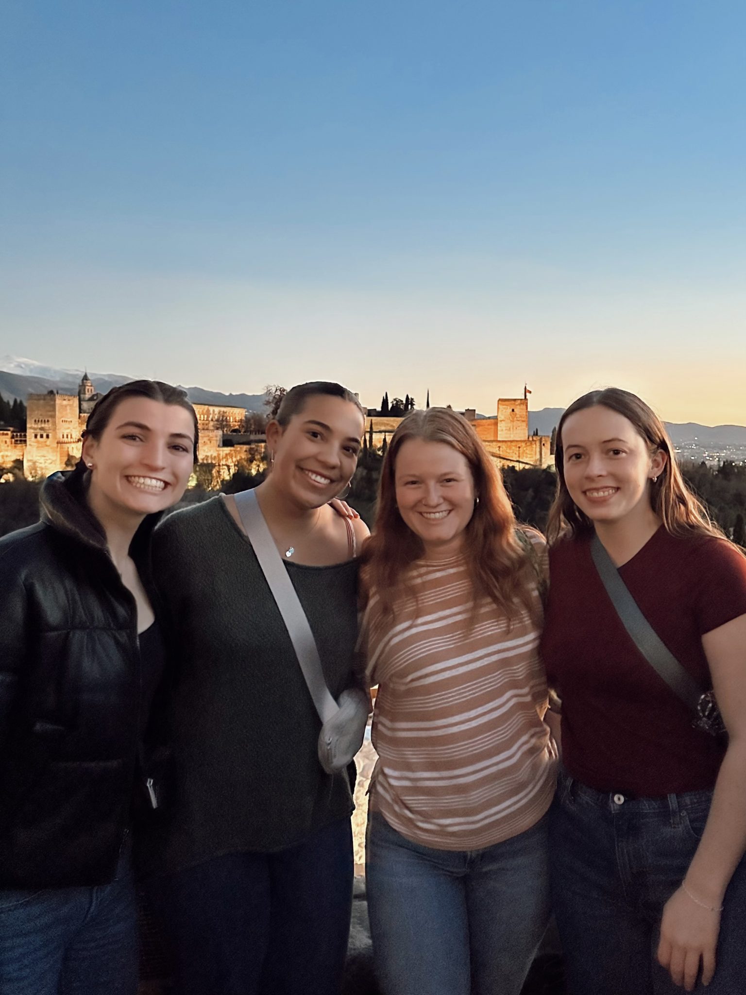 Four girls standing in front of an outlook to the Alhambra.