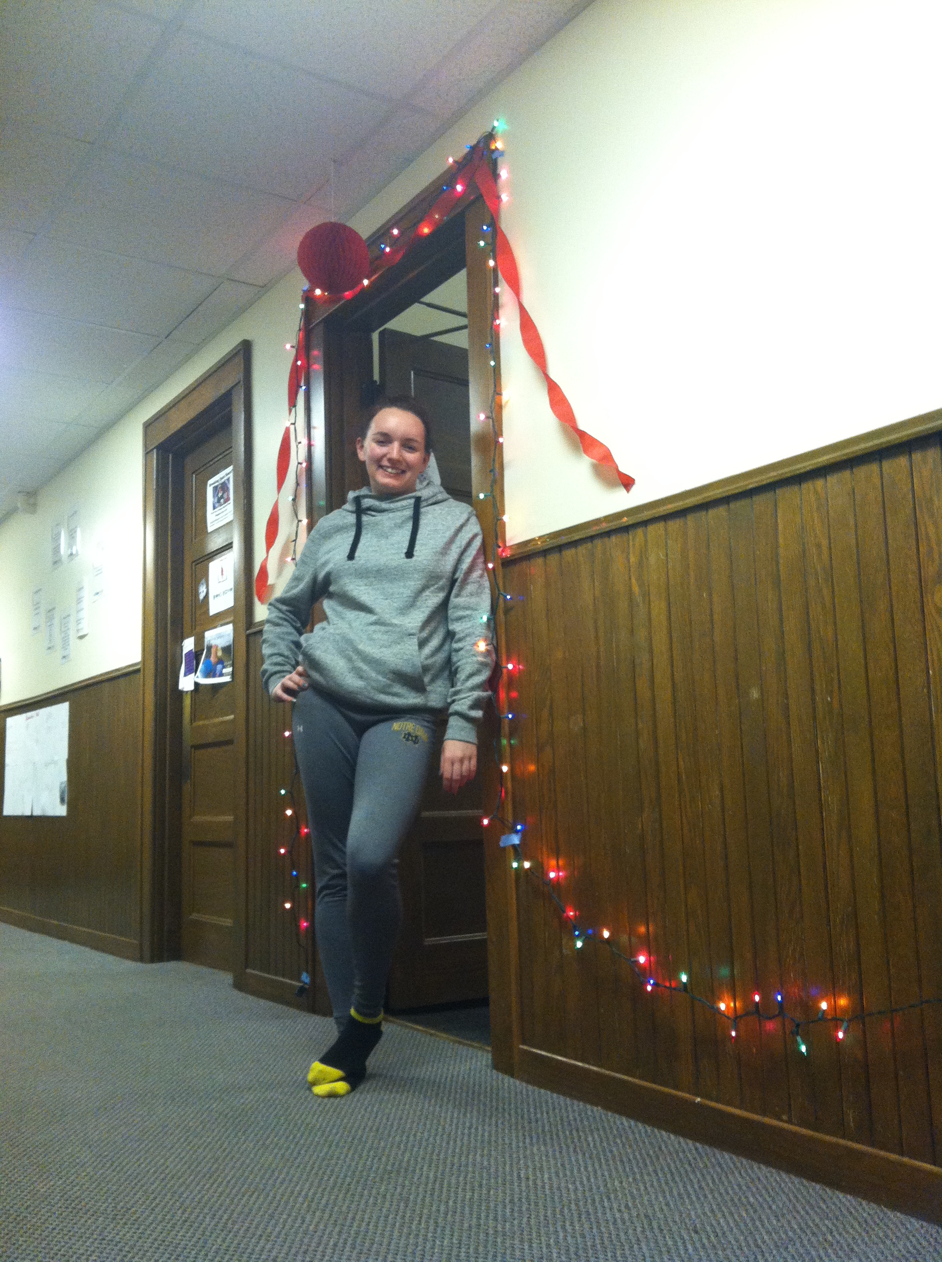 My roommate, Kristin, in front of Ashley and Abby's door with their colorful Christmas lights.