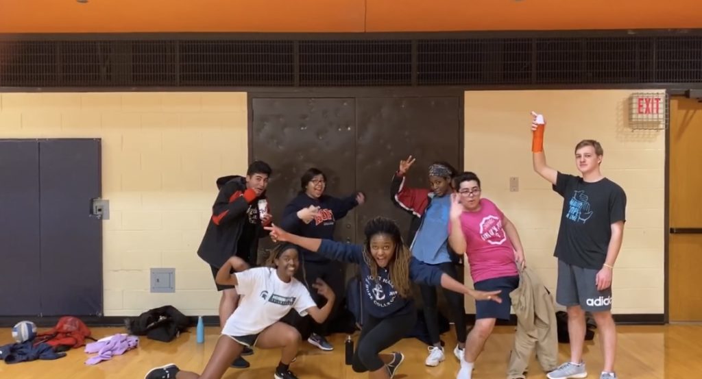 A group of Hope students wearing athletic clothing striking poses before their last volleyball game at the Dow gym. 