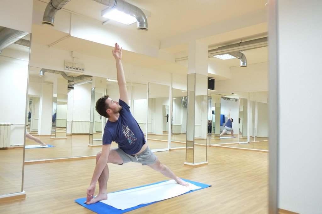 Donegan performs triangle in the yoga room.
